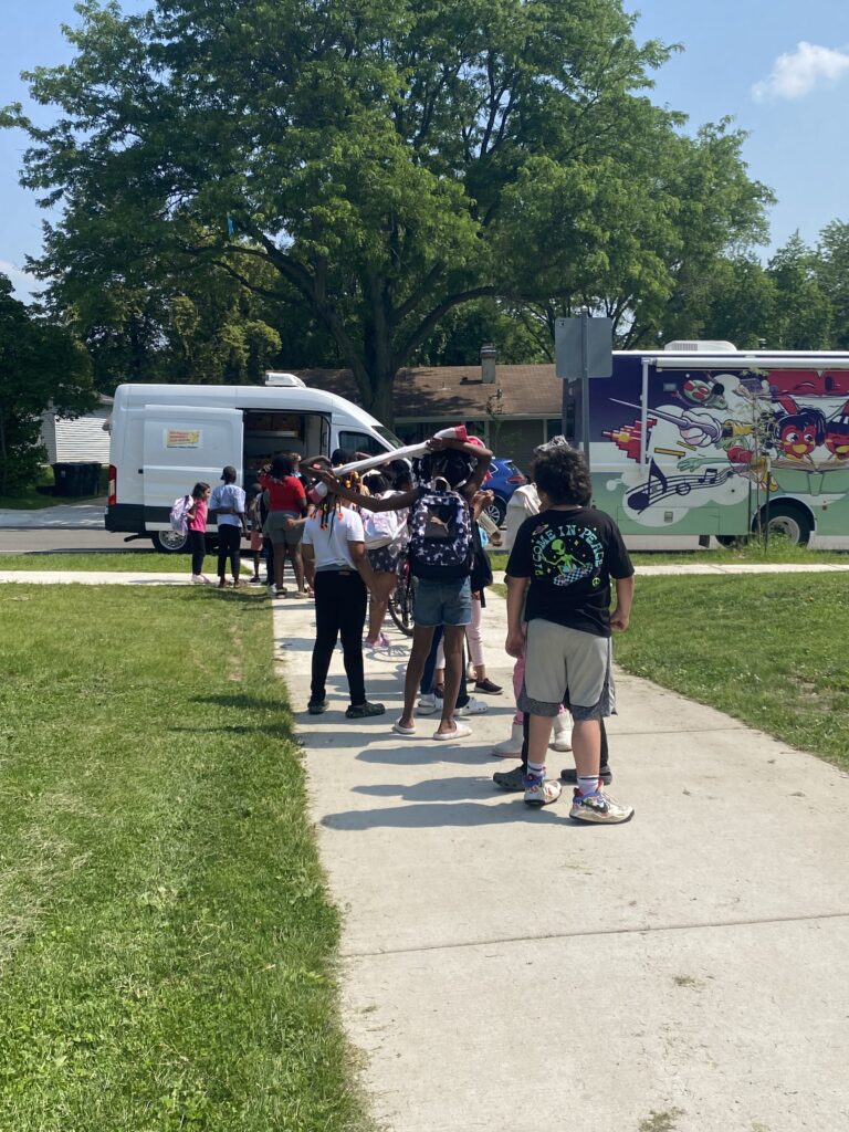 A long line of kids wait in front of the Sun Prairie Food Pantry truck to get snack bags for "Fun Fridays".