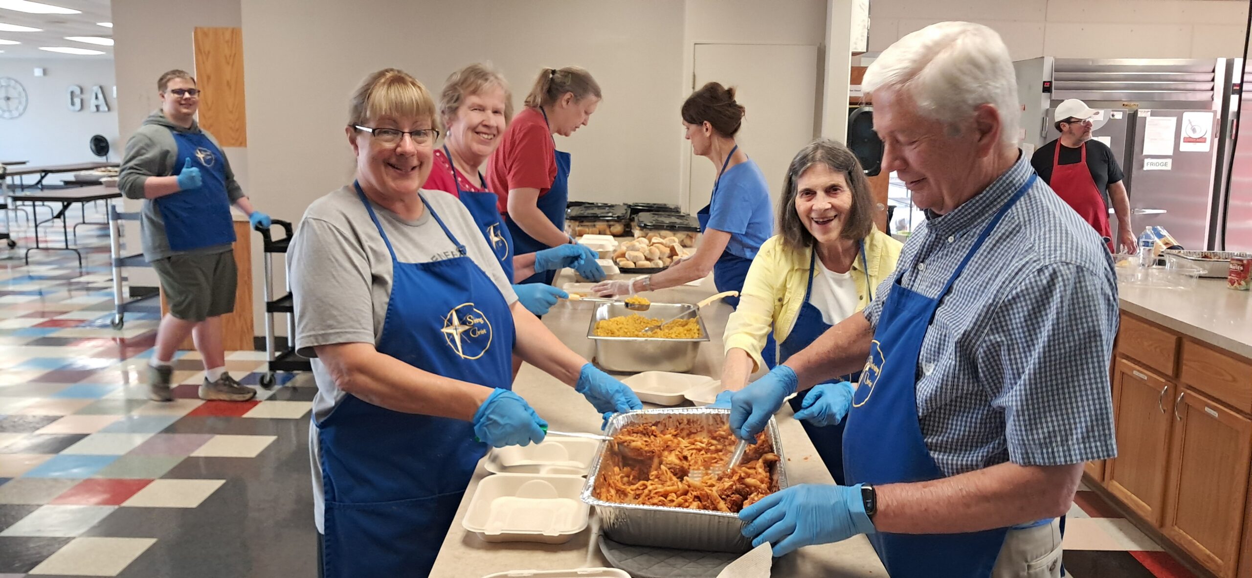 A group of volunteers prepares meals for Sunshine Supper.